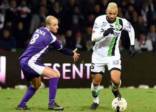 Photo: OH Leuven midfielder John Bostock (right) glides past an opponent in the Belgium top flight. (Courtesy Touchline Talk)