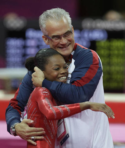 Photo: United States head coach John Geddert (right) hugs gymnast Gabrielle Douglas at the London 2012 Olympic Games. Geddert trains Trinidad and Tobago gymnast, Thema Williams, at his gym in Michigan. (Courtesy Desert News)