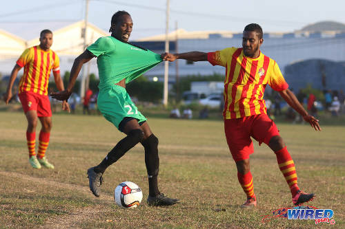 Photo: Point Fortin Civic left back Shaquille Stewart tries to help himself to the shirt of San Juan Jabloteh winger Nathan Lewis during TT Pro League action at the Barataria Recreation Ground, Barataria on 5 March 2016. (Courtesy Chevaughn Christopher/Wired868)