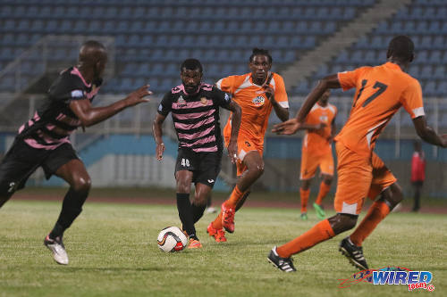 Photo: Veteran poacher Kerry Baptiste (centre) leads the charge for North East Stars during TT Pro League action at the Ato Boldon Stadium on 1 March 2016. Baptiste's teammate (far left) Anthony Wolfe tries to anticipate his pass while Club Sando midfield anchor Shannon Phillip (second from right) tries to keep up. (Courtesy Chevaughn Christopher/Wired868)