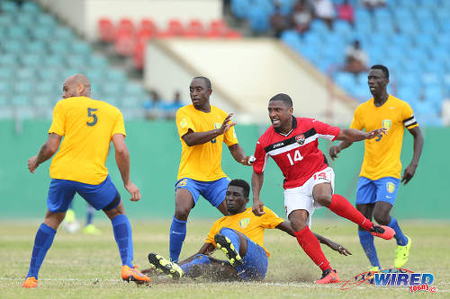 Photo: Trinidad and Tobago midfielder Andre Boucaud (centre) is surrounded by four St Vincent and the Grenadines players during Russia 2018 World Cup qualifying action at Arnos Vale on 25 March 2016. Trinidad and Tobago won 3-2. (Courtesy Allan V Crane/CA-images/Wired868)