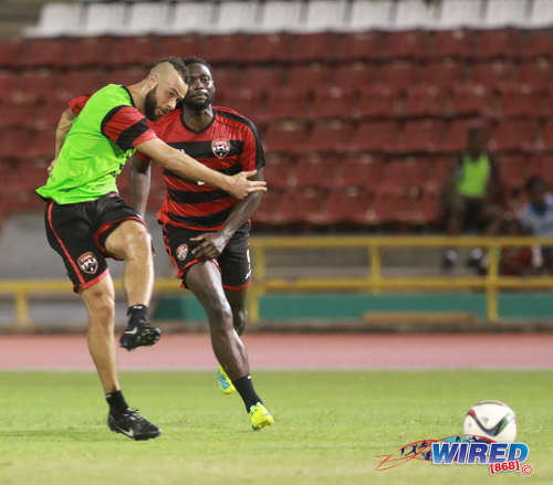 Photo: Trinidad and Tobago midfielder John Bostock (left) strikes the ball during national practice while team captain Kenwyne Jones look on at the Hasely Crawford Stadium on 21 March 2016. (Courtesy Nicholas Bhajan/Wired868)