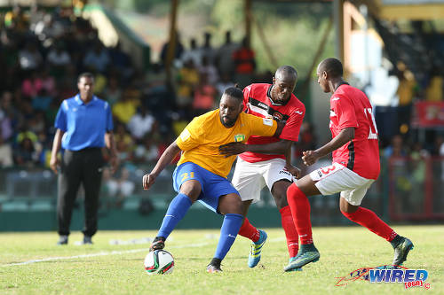 Photo: St Vincent and the Grenadines attacker David Pitt (left) holds off Trinidad and Tobago defender Daneil Cyrus (centre) while teammate Justin Hoyte looks on during Russia 2018 World Cup qualifying action at Arnos Vale on 25 March 2016. Trinidad and Tobago won 3-2. (Courtesy Allan V Crane/CA-images/Wired868)