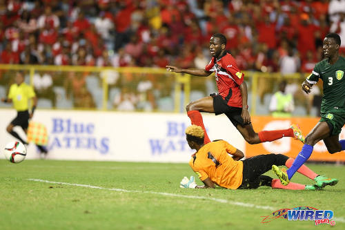 Photo: Trinidad and Tobago playmaker Kevin Molino (top) buries the ball past St Vincent and the Grenadines goalkeeper Lemus Christopher during Russia 2018 World Cup qualifying action at the Hasely Crawford Stadium, Port of Spain on 29 March 2016. Trinidad and Tobago won 6-0. (Courtesy: Allan V Crane/CA-images/Wired868)