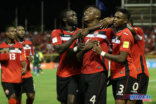 Photo: Trinidad and Tobago defender Sheldon Bateau (centre) is congratulated by teammates after grabbing the opening goal in a 6-0 win over St Vincent and the Grenadines at the Hasely Crawford Stadium, Port of Spain on 29 March 2016. (Courtesy: Allan V Crane/CA-images/Wired868)