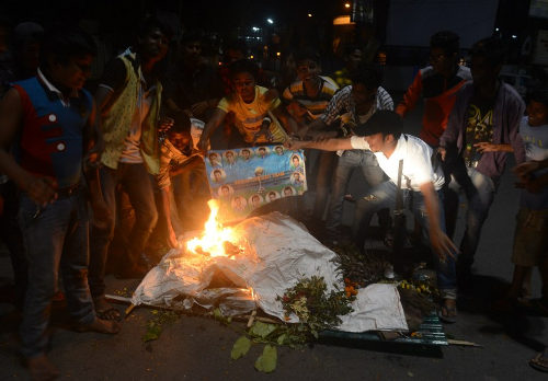 Photo: Indian cricket fans burn portraits of players as they stage a funeral of the Indian cricket team in the streets of Siliguri on 31 March 2016, after India's defeat in the men's semi-final match against the West Indies. (Copyright AFP 2016/Diptendu Dutta)