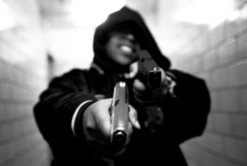 Photo: A thug shows off his weapons. (Courtesy Wehearit.com)