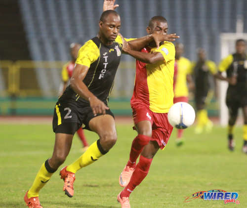 Photo: Defence Force defender Glen Franklin (left) holds off North East Stars forward Kerry Baptiste during Pro League on 19 April 2016 at the Hasely Crawford Stadium. Baptiste scored the winner as Stars won 1-0. (Courtesy Nicholas Bhajan/Wired868)