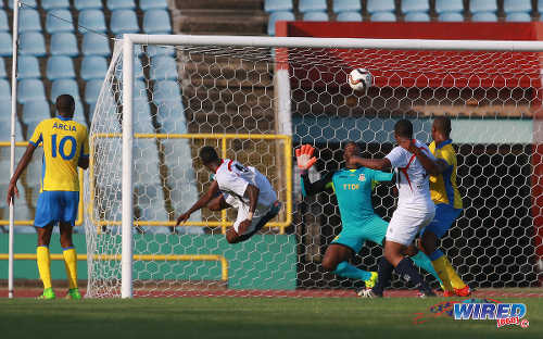 Photo: Morvant Caledonia United defender Ordell Flemming (second from left) acrobatically flicks his header past Defence Force custodian Sheldon Clarke during Lucozade Sport Goal Shield quarterfinal action on 9 April 2016. Morvant Caledonia won 5-1. (Courtesy Nicholas Bhajan/Wired868)