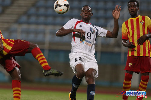 Photo: Morvant Caledonia United utility player Robert Primus (centre) tries to get out of the way of a Point Fortin Civic clearance during Lucozade Sport Goal Shield qualifying action on 5 April 2016 at the Ato Boldon Stadium, Couva (Courtesy Chevaughn Christopher/CA-images/Wired868)