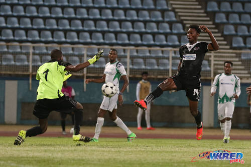 Photo: Central FC forward Nicholas Dillon (right) is closed down by DIRECTV W Connection goalkeeper Terrence Lewis during the Lucozade Sport Goal Shield semifinals on 15 April 2016. Connection won 4-2. (Courtesy Chevaughn Christopher/Wired868)