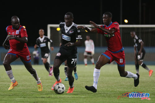 Photo: Central FC forward Rundell Winchester (centre) tries to escape from St Ann's Rangers players Sedale McLean (right) and Jeromie Williams during Lucozade Sport Goal Shield quarterfinal action on 8 April 2016. Central won 3-1 on kicks from the penalty mark. (Courtesy Chevaughn Christopher/CA-Images/Wired868)