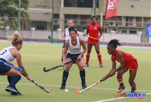 Photo: Trinidad and Tobago captain Kayla Brathwaite (right) takes on a group of United States players during their opening fixture of the 2016 Women's Junior Pan American Championship in Tacarigua on Thursday 31 March 2016. (Courtesy Nicholas Bhajan/Wired868)