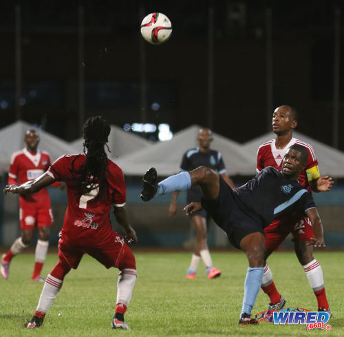 Photo: Police FC midfielder Kaaron Foster (centre) keeps his eye on the ball while Central FC players Leston Paul (right) and Jason Marcano look on during TT Pro League action on 2 April 2016. Police FC won 1-0. (Courtesy Chevaughn Christopher/CA-images/Wired868)