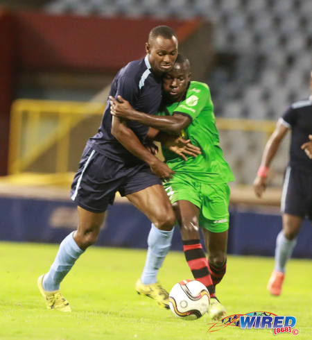 Photo: San Juan Jabloteh midfielder Fabian Reid (right) tries to hold on to Police FC forward Keon Wilson during Lucozade Sport Goal Shield quarterfinal action on 9 April 2016. Police won 3-0. (Courtesy Nicholas Bhajan/Wired868)