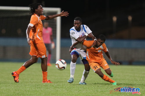 Photo: St Ann's Rangers attacker Johan Peltier (centre) wrestles with Club Sando midfielder Michael Basdeo (right) while his teammate Moron Phillip appeals to the referee during Lucozade Sport Goal Shield qualifying action on 5 April 2016 at the Ato Boldon Stadium, Couva (Courtesy Chevaughn Christopher/CA-images/Wired868)