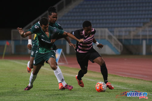 Photo: North East Stars midfielder Anthony Guppy (right) tries to break free of W Connection midfielder Paolo De La Guardia during Lucozade Sport Goal Shield quarterfinal action on 8 April 2016. Connection won 4-1. (Courtesy Chevaughn Christopher/CA-Images/Wired868)