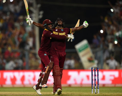 Photo: West Indies' Carlos Brathwaite (right) and teammate Marlon Samuels celebrate after victory in the World T20 cricket tournament final match between England and West Indies at The Eden Gardens Cricket Stadium in Kolkata on 3 April 2016. (Copyright AFP 2016/Dibyangshu Sarkar)