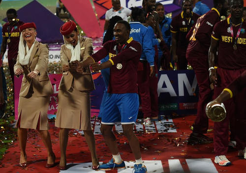 Photo: West Indies cricket star Dwayne Bravo (centre) dances with air hostesses after victory in the World T20 cricket tournament final match against England at The Eden Gardens Cricket Stadium in Kolkata on 3 April 2016.  (Copyright AFP 2016/Indranil Mukherjee)