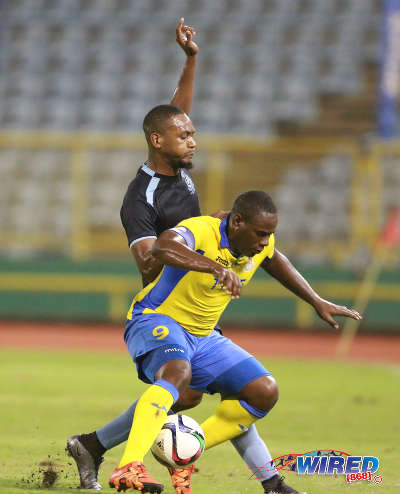 Photo: Defence Force striker Devorn Jorsling (right) holds off a Police FC defender during Pro League action at the Hasely Crawford Stadium on 3 May 2016. Jorsling scored the winner as Defence Force won 3-2. (Courtesy Nicholas Bhajan/Wired868)