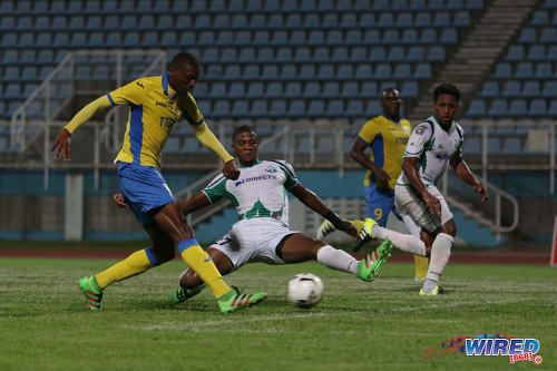 Photo: Defence Force striker Hashim Arcia (left) drives his shot past W Connection defender Jelani Peters (centre) while Maurice Ford looks on during the Digicel Pro Bowl final at the Ato Boldon Stadium on 27 May 2016. Defence Force won 2-1. (Courtesy Chevaughn Christopher/Wired868)