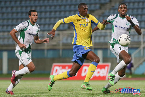 Photo: Defence Force attacker Hashim Arcia (centre) runs at W Connection defender Jelani Peters during the Digicel Pro Bowl final at the Ato Boldon Stadium on 27 May 2016. (Courtesy Chevaughn Christopher/Wired868)