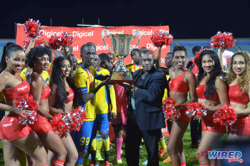 Photo: Defence Force captain Jerwyn Balthazar (centre) takes the Digicel Pro Bowl trophy after their 2-1 win over W Connection on 27 May 2016. (Courtesy Chevaughn Christopher/Wired868)