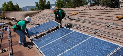 Photo: Workers install energy renewable solar panels on a rooftop. (Courtesy ucsusa.org)