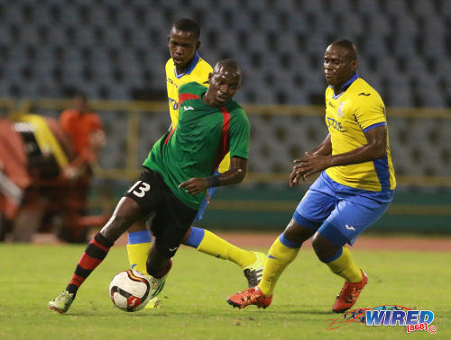 Photo: San Juan Jabloteh midfielder Fabian Reid (centre) tries to evade Defence Force captain Devorn Jorsling (right) and his teammate during 2016 Pro Bowl semifinal action on May 13 at the Hasely Crawford Stadium in Port of Spain. Defence Force won 1-0. (Courtesy Nicholas Bhajan/Wired868)