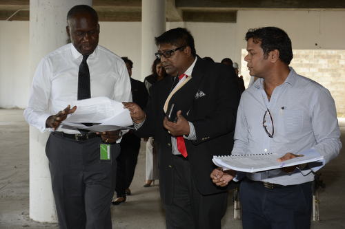 Photo: Minister of Communications and Public Administration Maxie Cuffie (far left) on a tour of the incomplete Chaguanas Library. (Courtesy Ministry of Communications)