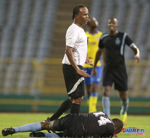 Photo: Referee Marlon Peruse (centre) stands over Police FC stand-in captain Kaaron Foster during Pro League action at the Hasely Crawford Stadium on 3 May 2016. Defence Force won 3-2. (Courtesy Nicholas Bhajan/Wired868)