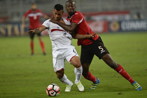 Photo: Trinidad and Tobago defender Daneil Cyrus (right) grapples with Peru full back Miguel Trauco during a friendly international match at the National stadium in Lima on 23 May 2016.  Peru won 4-0. (Copyright Ernesto Benavides/AFP 2016)