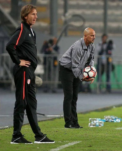 Photo: Trinidad and Tobago coach Stephen Hart (right) gives back the ball during international friendly action against Peru on May 23 while opposing coach Ricardo Gareca looks on. Peru won 4-0 in Lima.