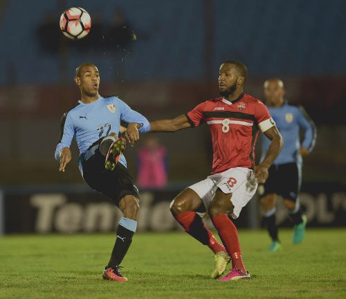 Photo: Uruguay attacker Diego Rolan (left) tries to keep the ball from Trinidad and Tobago midfielder Khaleem Hyland during friendly international action at the Centenario Stadium in Montevideo on 27 May 2016. (Copyright Miguel Rojo/AFP 2016/Wired868)