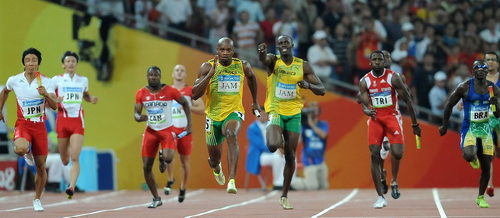 Photo: Trinidad and Tobago sprinter Richard Thompson (third from right) prepares to chase Jamaica star Asafa Powell (centre), as he receives the baton from Usain Bolt at the Beijing 2008 Olympic Games.