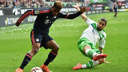 Photo: Bayern Munich winger and France international Kingsley Coman (left) takes on a Vfl Wolfsburg defender during Bundesliga action. (Copyright ESPN)