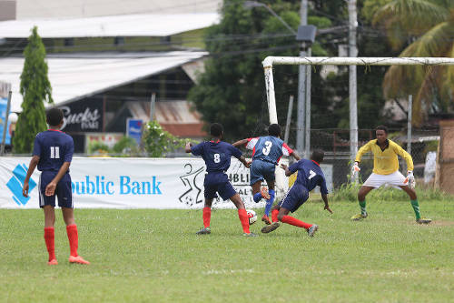 Photo: Malabar Young Stars attacker Jorel Grant (centre) squeezes between Mafeking United players Tamaar Williams (second from left) and Kirby Stewart (second from right) while goalkeeper Marc Mahabir gets ready during Republic Bank National Youth League action on 11 June 2016. (Courtesy Chevaughn Christopher/All Sport)