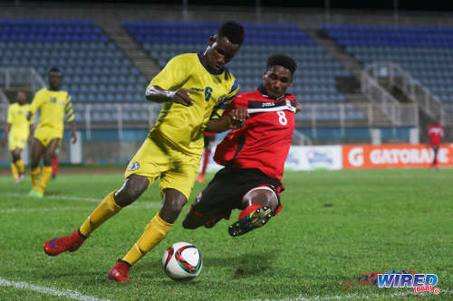 Photo: Trinidad and Tobago National Under-20 winger Jarred Dass (right) tackles St Lucia defender Melvin Doxilly during 2016 Caribbean Cup qualifying action at the Ato Boldon Stadium on 19 June 2016. The two teams played to a 1-1 draw. (Courtesy Chevaughn Christopher/Wired868)