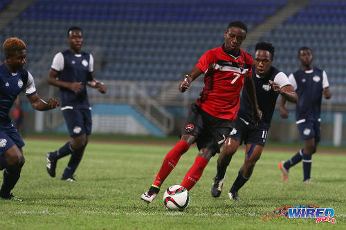 Photo: Trinidad and Tobago National Under-20 winger Isaiah Hudson (centre) runs at the Turks and Caicos defence during Caribbean Cup qualifying action at the Ato Boldon Stadium on 17 June 2016. T&T won 11-0. (Courtesy Chevaughn Christopher/Wired868)