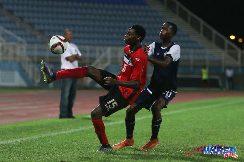 Photo: Trinidad and Tobago National Under-20 midfielder Kathon St Hillaire (left) controls the ball under pressure from Turks and Caicos player Ras Diamond during Caribbean Cup qualifying action at the Ato Boldon Stadium on 17 June 2016. T&T won 11-0. (Courtesy Chevaughn Christopher/Wired868)