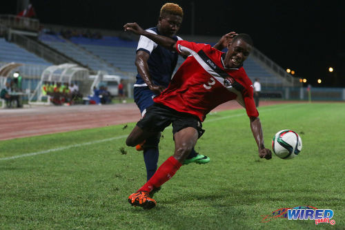 Photo: Trinidad and Tobago National Under-20 right back Kori Cupid (right) tries to keep his balance after pressure from a Turks and Caicos player during Caribbean Cup qualifying action at the Ato Boldon Stadium on 17 June 2016. T&T won 11-0. (Courtesy Chevaughn Christopher/Wired868)