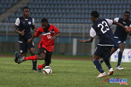 Photo: Trinidad and Tobago National Under-20 midfielder Micah Lansiquot (centre) takes on the Turks and Caicos defence during Caribbean Cup qualifying action at the Ato Boldon Stadium on 17 June 2016. T&T won 11-0. (Courtesy Chevaughn Christopher/Wired868)