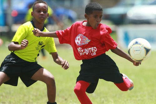 Photo: A Pinto United SC player (right) prepares to strike the ball, despite the attentions of an Adrenaline FA opponent, during Republic Bank National Youth League East Zone Under-12 action on 4 June 2016. Pinto won 4-0. (Courtesy Allan V Crane/CAI Sports/All Sport)