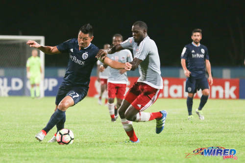 Photo: Central FC defender Keion Goodridge (right) tries to hold off Sporting Kansas City attacker Roger Espinoza during CONCACAF Champions League action at the Ato Boldon Stadium in Couva on 16 August 2016. Both teams played to a 2-2 draw. (Courtesy Chevaughn Christopher/Wired868)