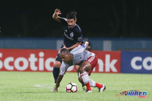 Photo: Central FC captain Leston Paul (right) tries to hold off a Sporting Kansas City opponent during CONCACAF Champions League action at the Ato Boldon Stadium in Couva on 16 August 2016. Both teams played to a 2-2 draw. (Courtesy Chevaughn Christopher/Wired868)