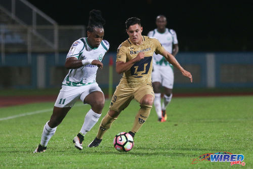 Photo: W Connection attacker Neil Benjamin Jr (left) tries to power past Pumas UNAM midfielder Alan Acosta during CONCACAF Champions League action in Couva on 3 August 2016. Pumas won 4-2. (Courtesy Chevaughn Christopher/Wired868)