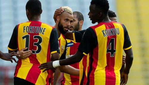 Photo: Lens midfielder John Bostock (centre) is congratulated by his teammates.