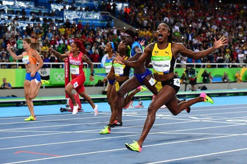 Photo: Jamaica's Elaine Thompson celebrates winning the Women's 100m Final at the Rio 2016 Olympic Games in Rio de Janeiro on 13 August 2016.  Trinidad and Tobago's Michelle-Lee Ahye is second from left. (Copyright: AFP 2016/Franck Fife)