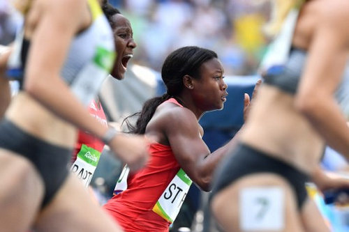 Photo: Trinidad and Tobago’s Khalifa St Fort (right) grabs the baton from teammate Kelly Ann Baptiste in the Women’s 4 x 100m Relay Round 1 at the Rio 2016 Olympic Games on 18 August 2016.  (Copyright Jewel Samad/AFP 2016)