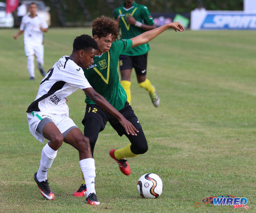 Photo: St Benedict's College player Mickel Ravello (right) tries to get around a St Augustine Secondary opponent during SSFL Premier Division action at the Mahaica Oval on 17 September 2016. (Courtesy Sean Morrison/Wired868)